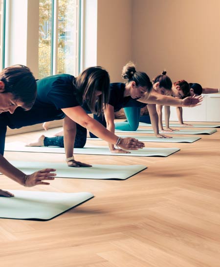 groupe qui fait du yoga sur des tapis